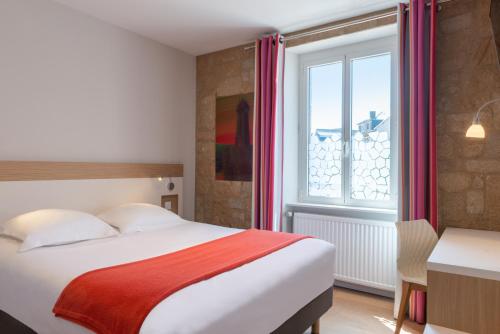 a hotel room with a bed and a window at Hôtel de Perros, The Originals Boutique in Perros-Guirec