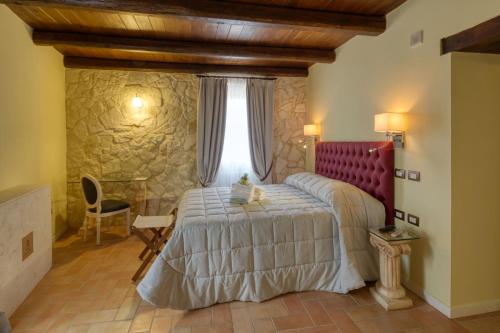 a bedroom with a bed with a red headboard at Borgo Incantato Spoleto in Pompagnano