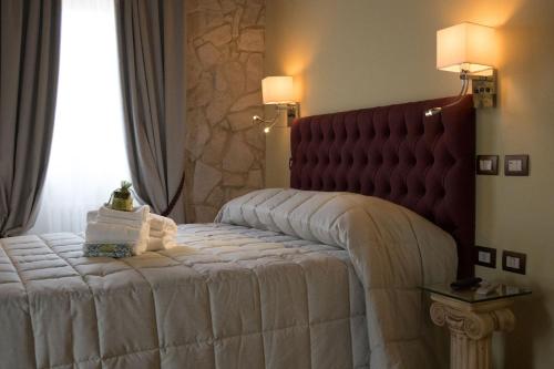 a bedroom with a large white bed with a red headboard at Borgo Incantato Spoleto in Pompagnano