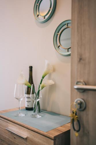 a table with two glasses and a bottle of wine and flowers at Villa17 in Badacsonytomaj
