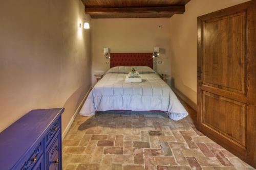 a bedroom with a bed and a wooden cabinet at Borgo Incantato Spoleto in Pompagnano