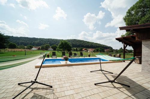 a swimming pool with two chairs and a hammock at Vén Diófa in Sub Cetate