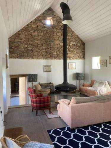 un salon avec un canapé et une cheminée dans l'établissement LocMajan, à Plouguin