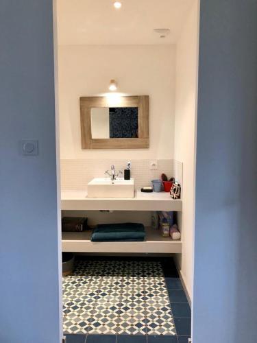 une salle de bain avec un lavabo et un miroir dans l'établissement LocMajan, à Plouguin