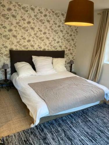 1 dormitorio con 1 cama grande con almohadas blancas en LocMajan, en Plouguin