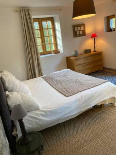 Un dormitorio con una cama grande y una ventana en LocMajan, en Plouguin