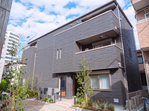 a black brick building with a window at GRAND BASE Sumiyoshi in Fukuoka