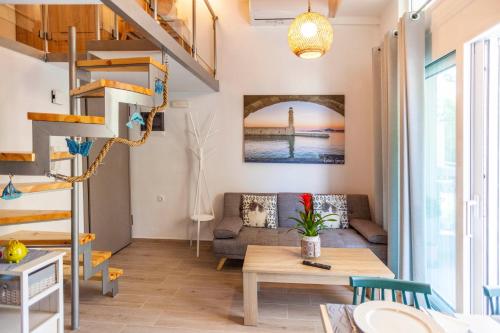 sala de estar con escalera de caracol y sofá en Rethymno Garden Suites en Rethymno