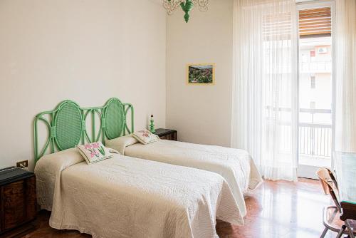 a bedroom with two beds with white sheets and a window at Appartamento "Casa Mia" Florence in Florence