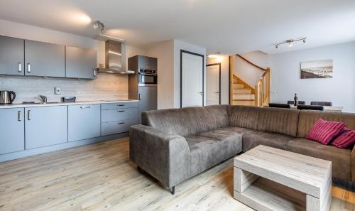 ein Wohnzimmer mit einem Sofa und einem Tisch in der Unterkunft Vakantiehuis Rehoboth in Domburg