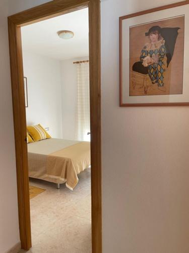 Habitación con una foto en la pared junto a una cama en CASA LIMÓN, en Cunit