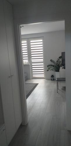 Habitación con un pasillo con ventana y suelo de madera. en Apartament WIK-MAR en Elblag