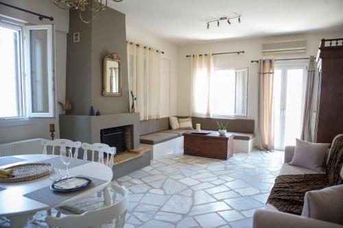 Skinos House في Vári: غرفة معيشة مع طاولة ومدفأة