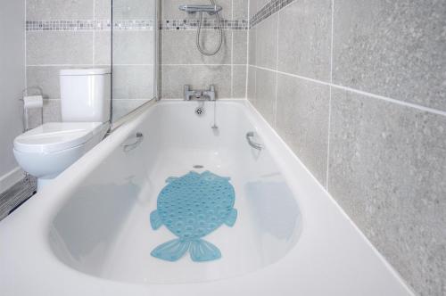a bathroom with a bath tub with a toilet and a fish on it at St Julians View - 1 Bedroom Apartment - Tenby in Tenby