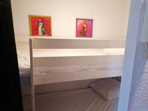 卡諾海灘的住宿－Charmant studio Residence Carnon plage-Climatisation-Parking Prive，卧室配有一张双层床,墙上挂有两张照片