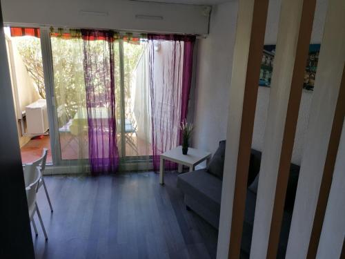 - un salon avec un canapé et une fenêtre dans l'établissement Charmant studio Residence Carnon plage-Climatisation-Parking Prive, à Carnon-Plage