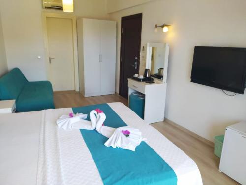 a hotel room with a bed with towels on it at Alya Hotel Göcek in Göcek