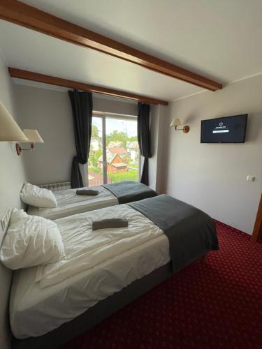 uma cama grande num quarto de hotel com uma janela em Plytų 9 em Palanga