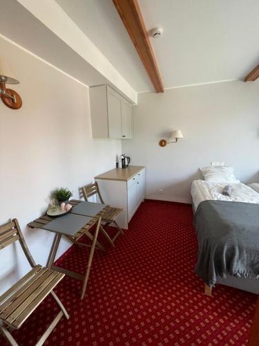 a small room with a bed and a table and chairs at Plytų 9 in Palanga