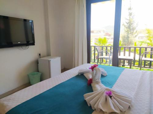 a little girl in a dress laying on a bed at Alya Hotel Göcek in Göcek