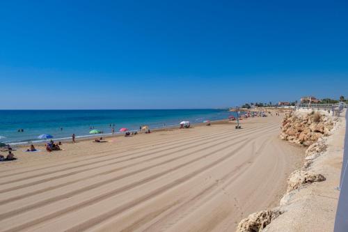 a group of people on a beach with the ocean at La Petite Erika in Avola