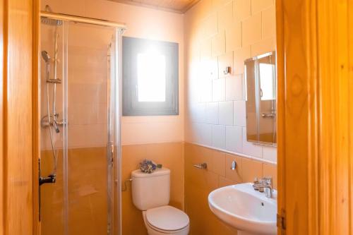 Un baño con inodoro, lavabo y ducha. en Aldea Los Odres - Cabañas de Madera de 1ª con Piscina Privada y BBQ en la puerta, en Moratalla