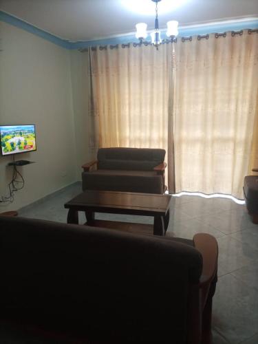 a living room with two couches and a coffee table at Legend Executive Suites in Fort Portal