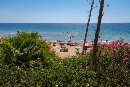 a beach with a bunch of people in the water at La Petite Erika in Avola