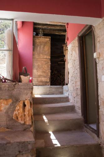 a staircase leading to a room with pink walls at Skinos House in Vari