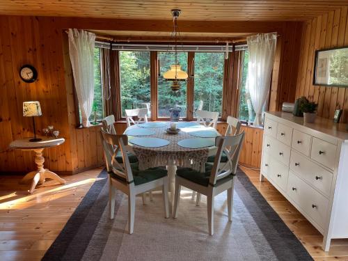 ein Esszimmer mit einem Tisch und Stühlen in der Unterkunft Fyrvägen 13 'Ydermossa' NEW! in Munka-Ljungby