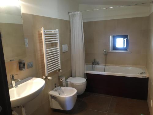 y baño con bañera, aseo y lavamanos. en Hotel Torre Domini, en Giovinazzo