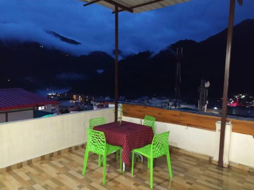 a table and chairs on a balcony with a view at Hotel The Shivaay - Delight Inn Rishikesh in Rishīkesh