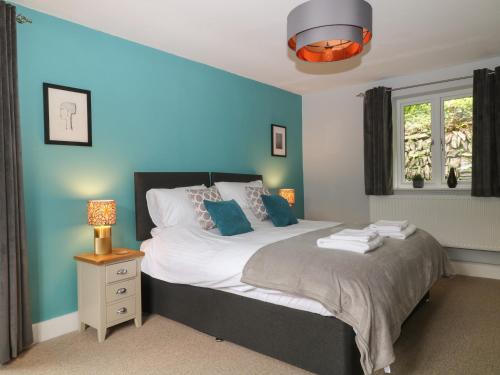 um quarto com uma cama com uma parede azul em Ferndale em Lynton