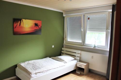 ベルギッシュ・グラートバッハにあるWork and Stay Bergisch Gladbachの緑のベッドルーム(ベッド1台、窓付)