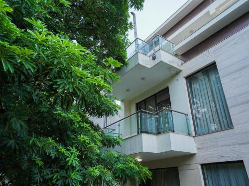 un balcón en un edificio con árboles en el primer plano en Lime Tree Sector 29 Gurgaon Sushant Lok at Iffco Metro en Gurgaon