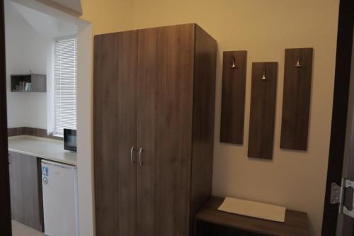 a kitchen with a large wooden cabinet in a room at Family Hotel Dreams in Sozopol