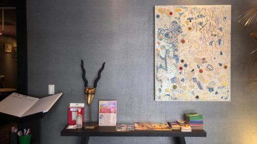 a table with books and a painting on a wall at Taipei 101 SPARKLE Hotel in Taipei