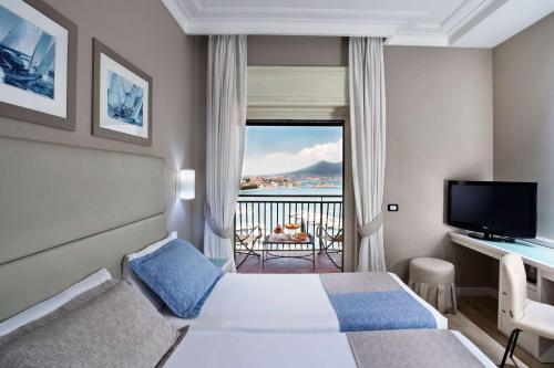 um quarto de hotel com uma cama e uma varanda em BW Signature Collection Hotel Paradiso em Nápoles