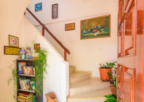 a staircase with a book shelf with books at Savas Rooms in Palaiochora