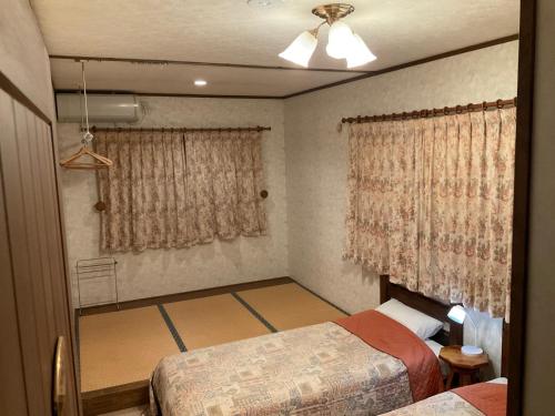 a small bedroom with two beds and a window at Landhaus Dancru Netz in Hakuba