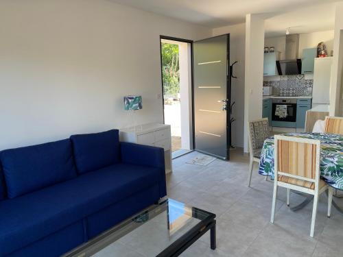 sala de estar con sofá azul y mesa en Petite maison - annexe indépendante d'une villa / Independent Guesthouse within a villa, en Corneilla-del-Vercol