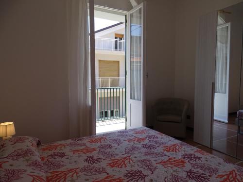 a bedroom with a bed and a window and a chair at Casa Jacopo 50 mt dal mare in Levanto