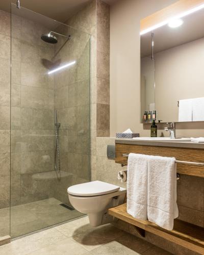 a bathroom with a toilet and a glass shower at Hotel Vík í Mýrdal in Vík