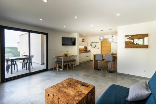 un salon avec un canapé bleu et une table dans l'établissement U CAVALLU - Luxe entre Mer et Montagne, à Santa-Maria-di-Lota