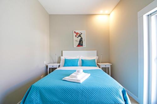 - une chambre dotée d'un lit bleu avec des draps bleus dans l'établissement Casa São Vicente - Apartment Near City Centre with Private Parking, à Viana do Castelo