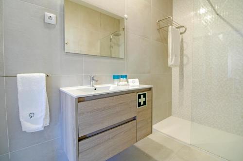 a bathroom with a sink and a shower at Casa São Vicente - Apartment Near City Centre with Private Parking in Viana do Castelo
