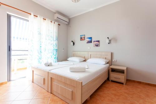 a bedroom with a large bed and a large window at Toni Retzo Rooms in Himare