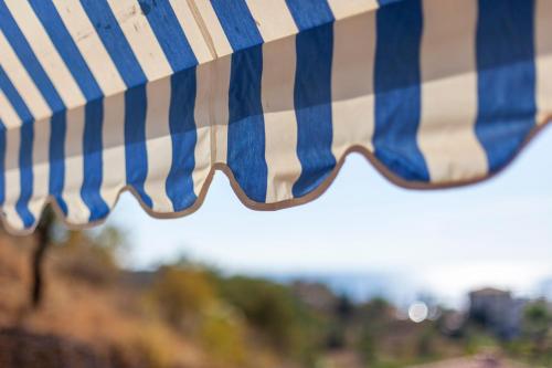 a close up of a blue and white striped umbrella at Toni Retzo Rooms in Himare