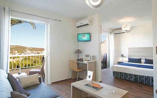 リル・ルッスにあるHotel Funtana Marinaのベッドとリビングルームが備わるホテルルームです。