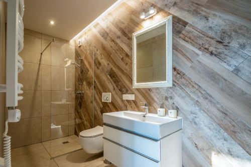 a bathroom with a sink and a toilet and a mirror at Vila „Neptūnas“ in Palanga